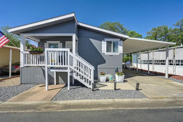 a view of a house with a yard and porch