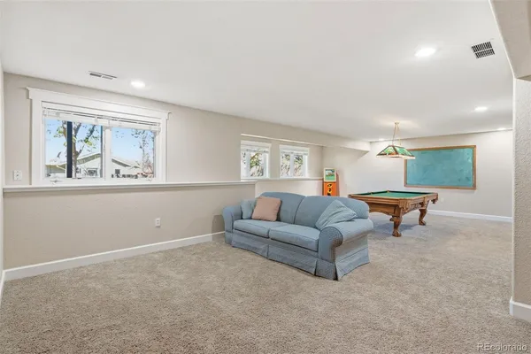 a room with furniture pool table and window
