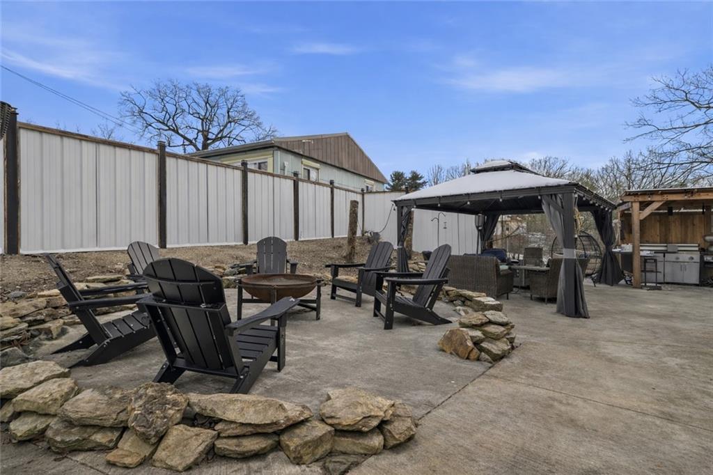 804 Erdner Avenue Pittsburgh, PA 15202 - Photo 33 of 48 a view of a patio with table and chairs under an umbrella with large trees