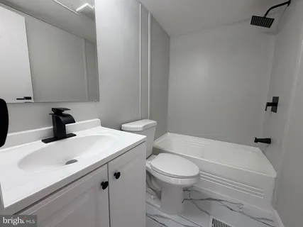 a bathroom with a sink a toilet and bathtub