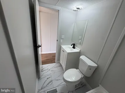 a white toilet sitting next to a sink and vanity