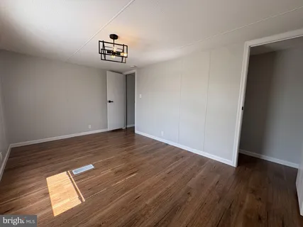 a view of a room with wooden floor and white walls