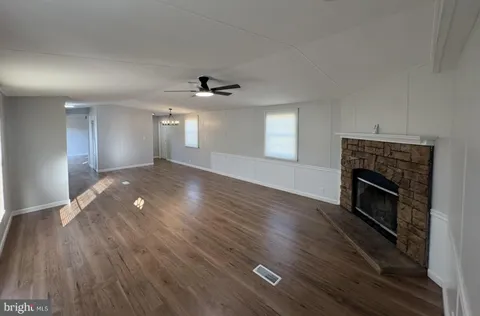 a view of an empty room with a fireplace and a window