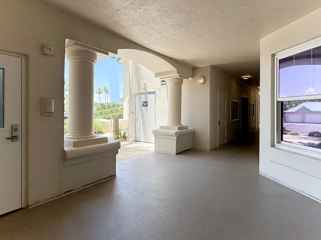 a view of a hallway to rooms