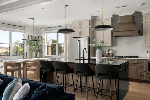 a kitchen with stainless steel appliances granite countertop a sink a stove and chairs