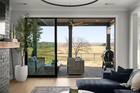 a living room with furniture and a floor to ceiling window