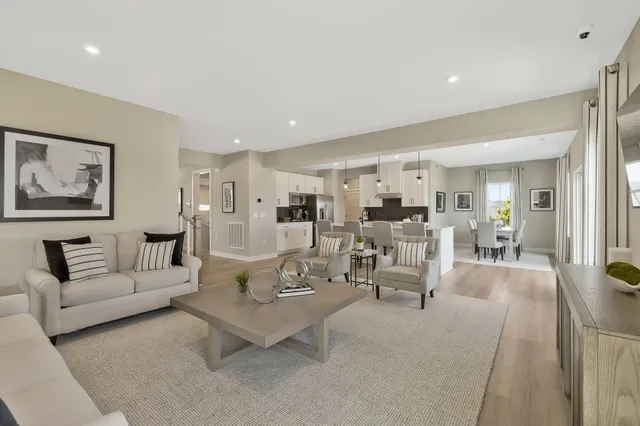 a living room with furniture and view of kitchen