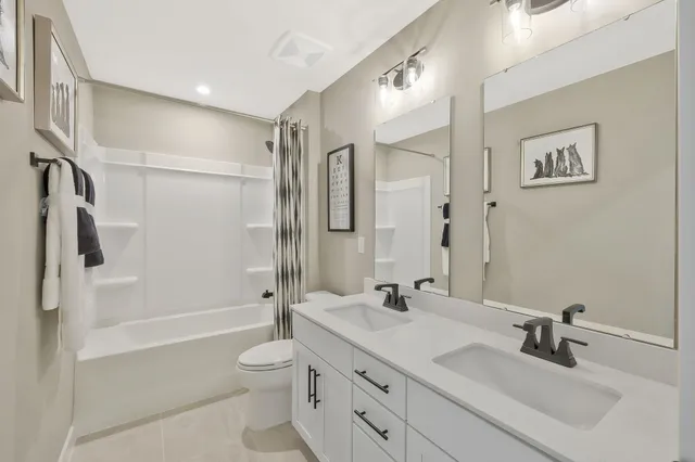 a bathroom with a double vanity sink toilet tub and shower