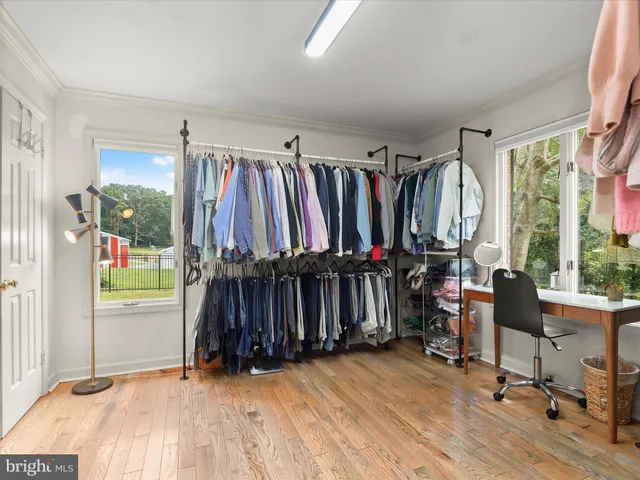 a kitchen with stainless steel appliances white cabinets a sink dishwasher a stove and a refrigerator with wooden floor