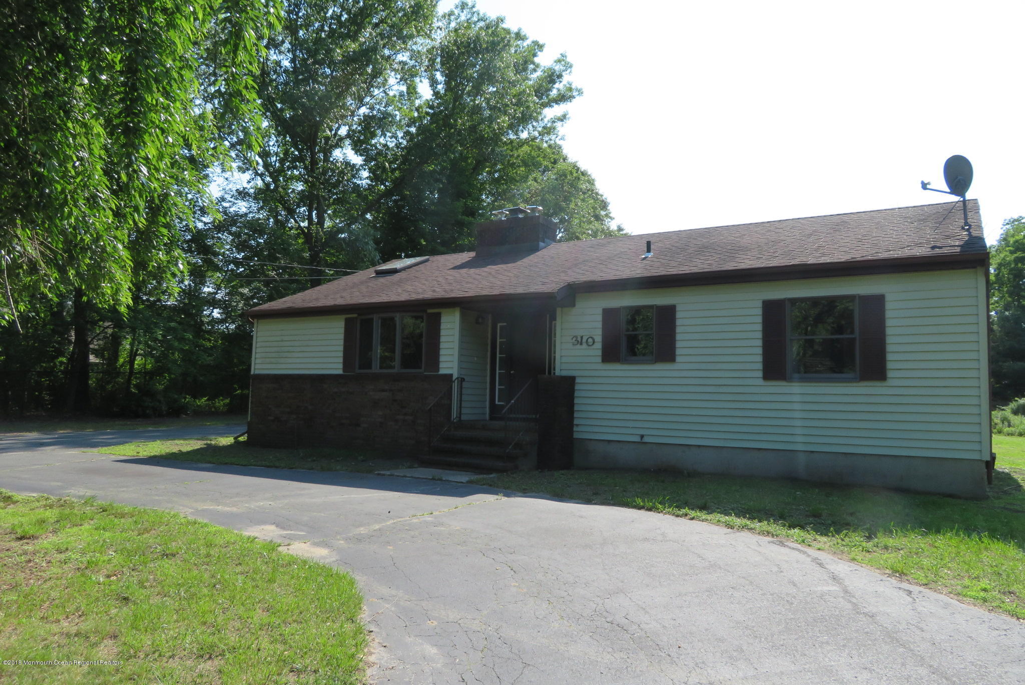 310 Colts Neck Road Farmingdale, NJ 07727 - Photo 1 of 15 a front view of a house with a garden