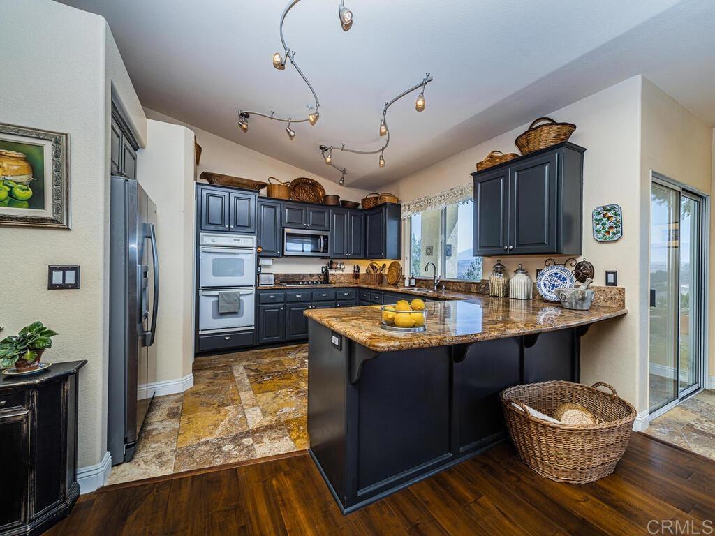 30568 Roadrunner Ridge Valley Center, CA 92082 - Photo 15 of 56 a kitchen with stainless steel appliances granite countertop a sink stove and refrigerator