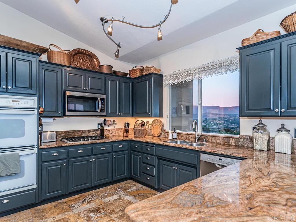 30568 Roadrunner Ridge Valley Center, CA 92082 - Photo 16 of 56 a kitchen with stainless steel appliances granite countertop a sink stove and cabinets
