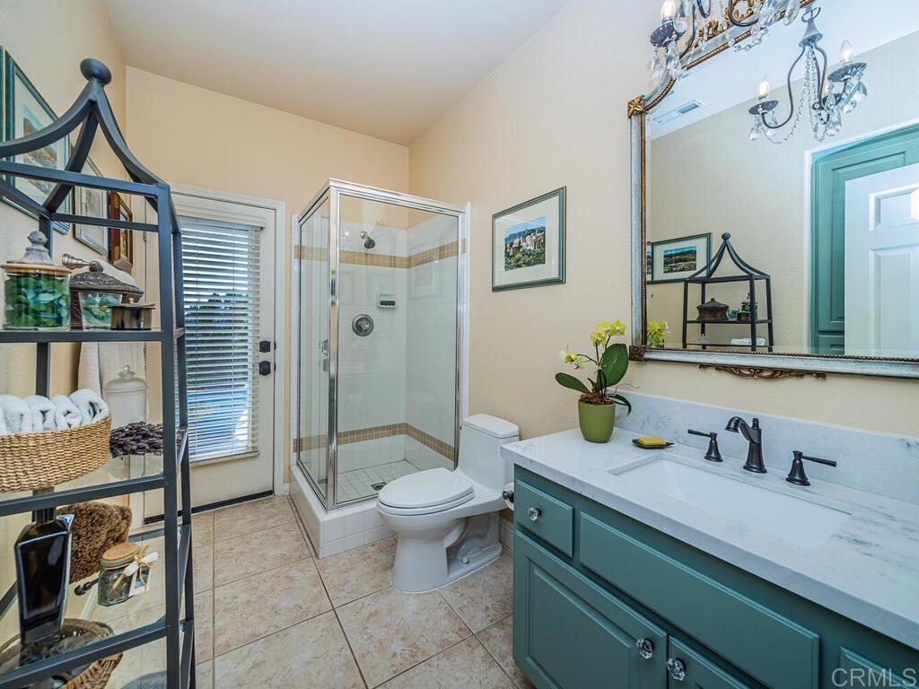 30568 Roadrunner Ridge Valley Center, CA 92082 - Photo 29 of 56 a bathroom with a granite countertop sink a toilet a mirror and shower