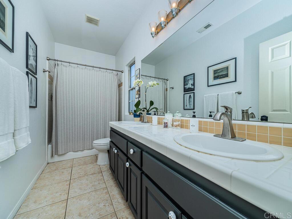 30568 Roadrunner Ridge Valley Center, CA 92082 - Photo 32 of 56 a bathroom with a granite countertop sink mirror and shower