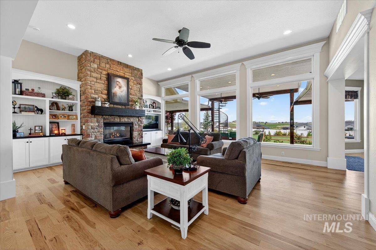 414 East Shafer View Drive Meridian, ID 83642 - Photo 6 of 50 A spacious 19x12 Great Room w/12" ceiling, a bank of Windows to take in the Unobstructed Mtn. View, Tons of natural light, Floor to Ceiling Stone Gas Fireplace with Wood Plank Mantel & hearth, Painted built-in bookshelves, ceiling fan & canned lighting.