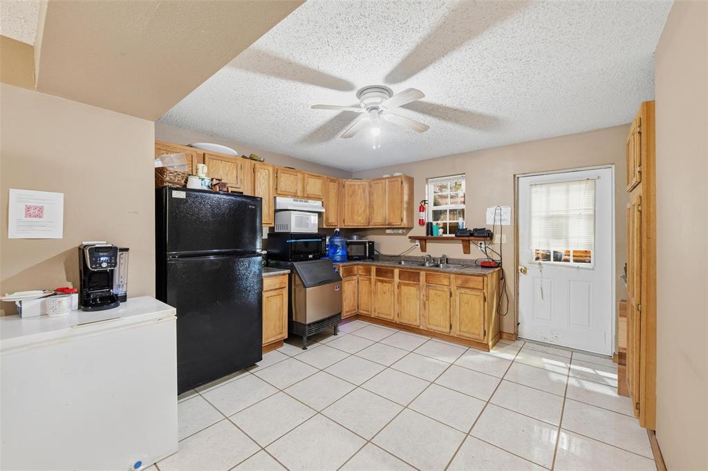 9510 Swafford Road Justin, TX 76247 - Photo 24 of 28 a kitchen with a refrigerator a microwave a sink and a stove
