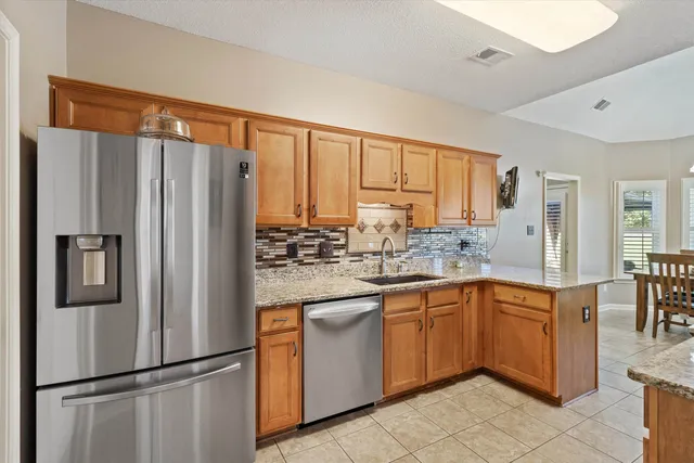a kitchen with stainless steel appliances granite countertop a refrigerator and a sink