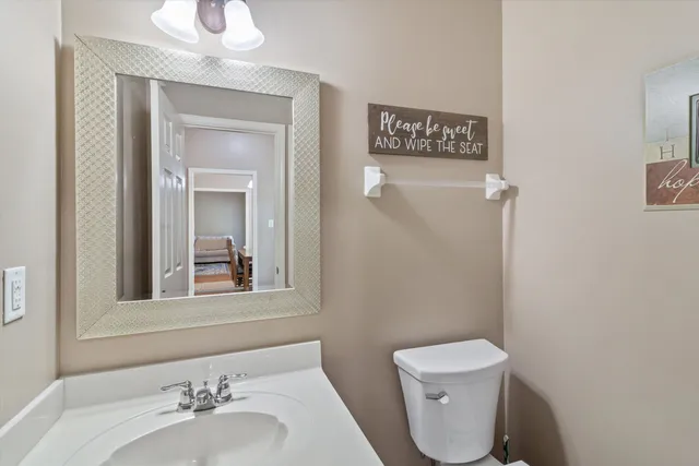 a bathroom with a toilet sink and mirror