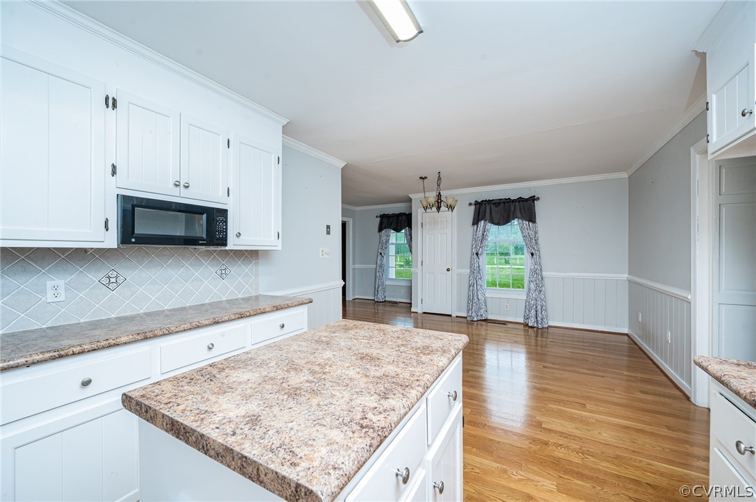 22508 Carson Road Dinwiddie, VA 23841 - Photo 7 of 50 a kitchen with stainless steel appliances granite countertop a stove top oven a sink and white cabinets with wooden floor