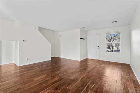 a view of an empty room with wooden floor