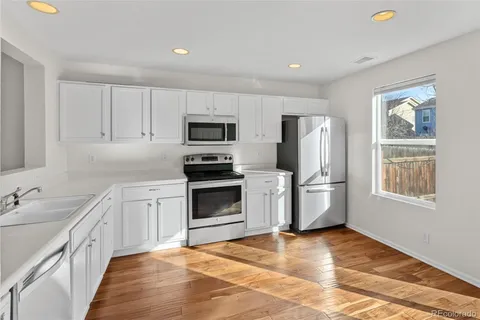 a kitchen with stainless steel appliances a stove refrigerator sink and microwave
