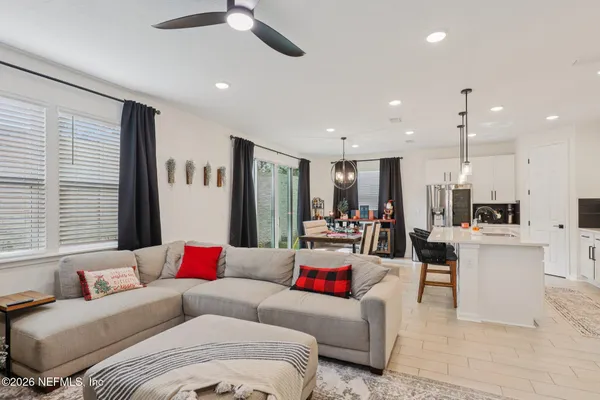 a living room with furniture kitchen and a chandelier