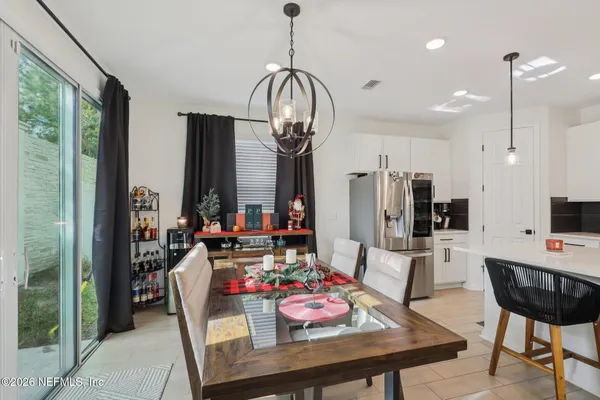 a view of a dining room with furniture a chandelier and wooden floor