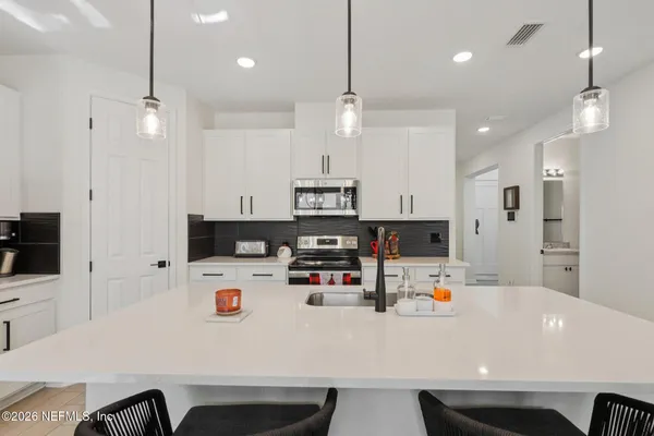 a white kitchen with stainless steel appliances and a white cabinets