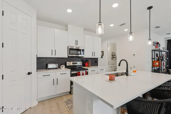 a kitchen with kitchen island a white counter top space cabinets and stainless steel appliances