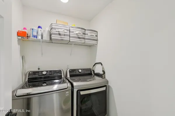 a utility room with dryer washer and empty racks