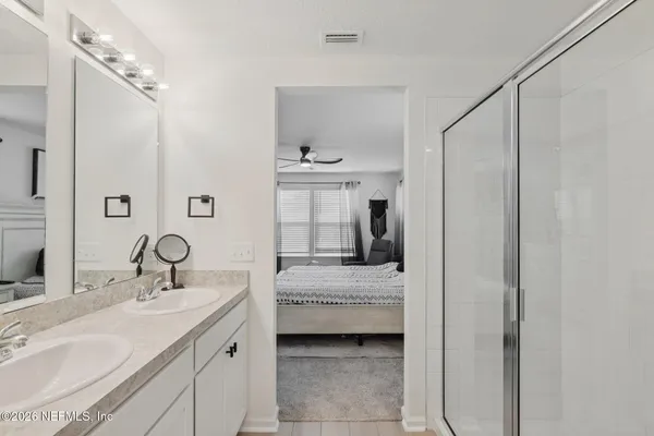 a en suite bathroom with a sink double vanity and mirror