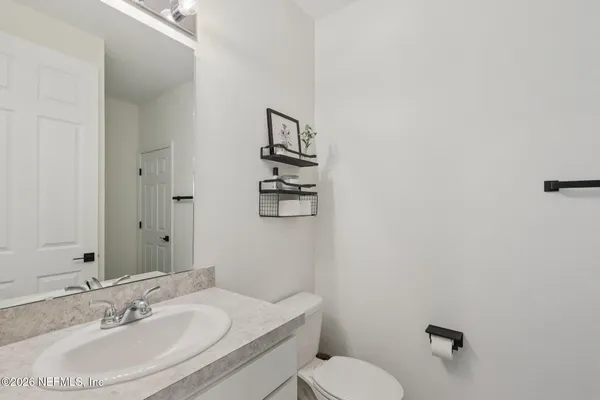 a bathroom with a sink a toilet and mirror