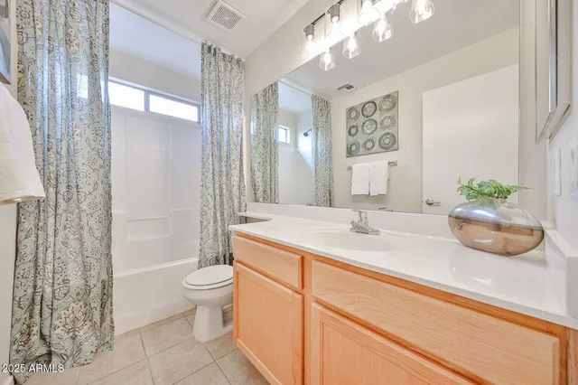 a bathroom with a granite countertop sink a toilet a mirror and shower