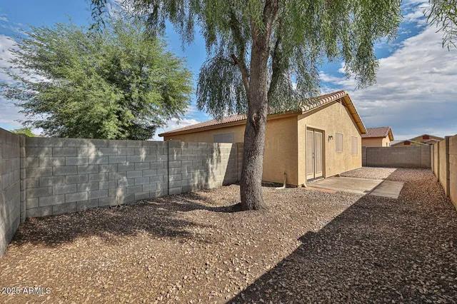 a view of a house with backyard and trees