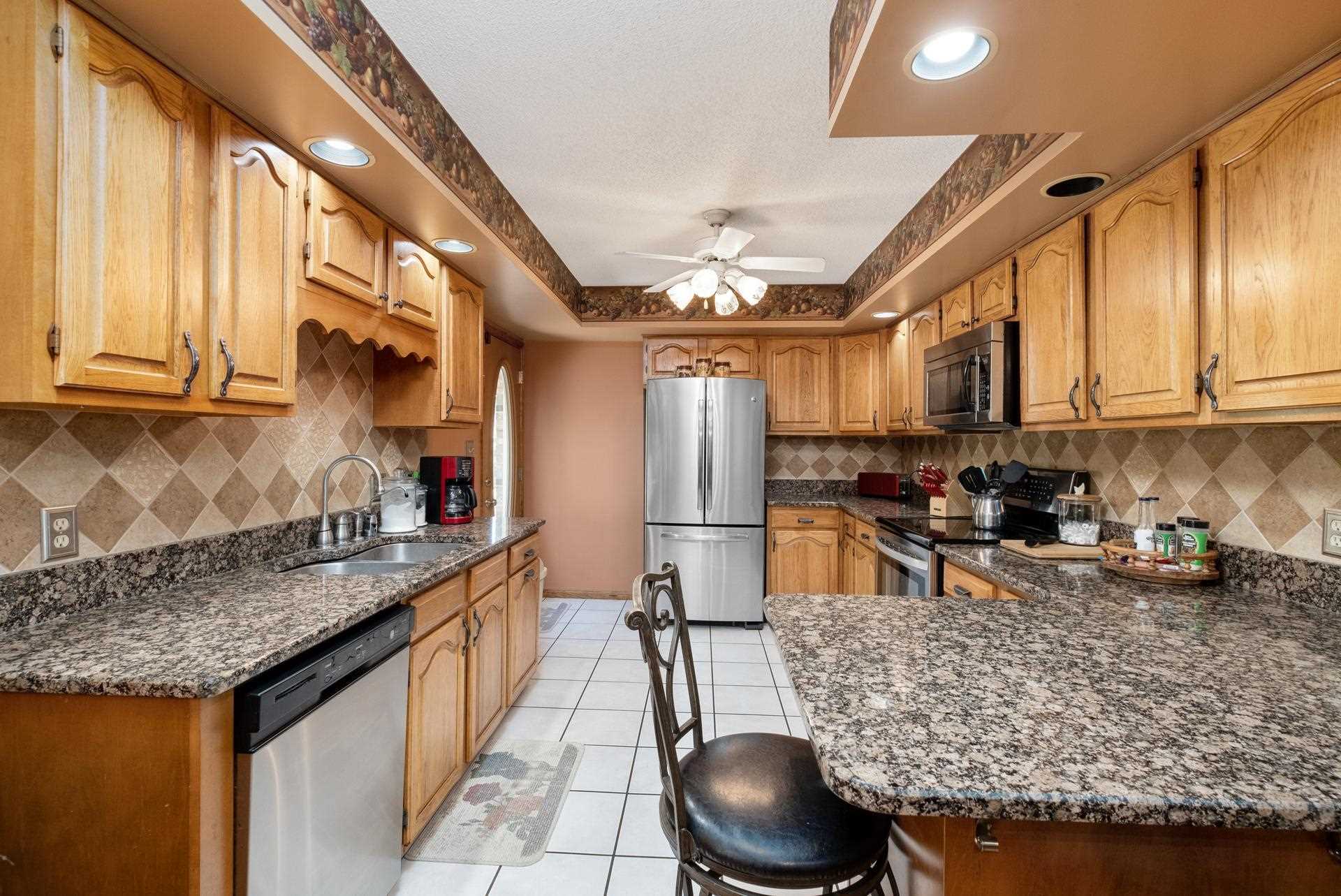 556 Buttermilk Spring Road Staunton, VA 24401 - Photo 17 of 67 a kitchen with stainless steel appliances granite countertop a sink a stove and a wooden cabinets