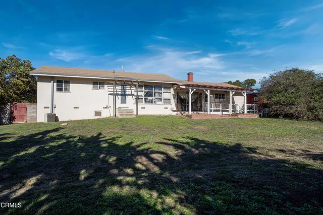 a view of a backyard with potted plants and wooden fence