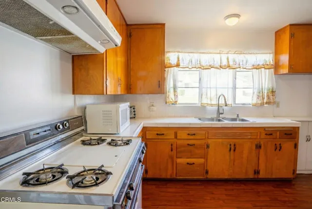 a kitchen with a stove a sink and a microwave