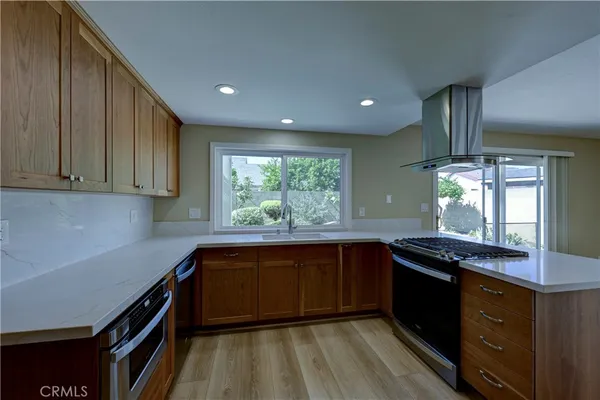 a kitchen with stainless steel appliances granite countertop a sink stove and refrigerator