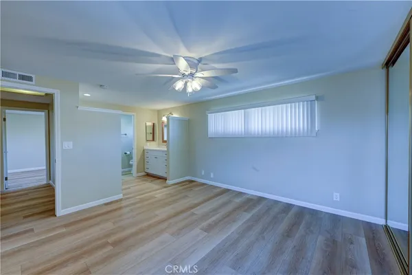 a spacious bathroom with a double vanity sink a large mirror a toilet and a vanity