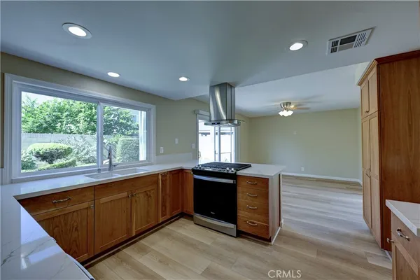 a kitchen with granite countertop stainless steel appliances a sink stove and cabinets