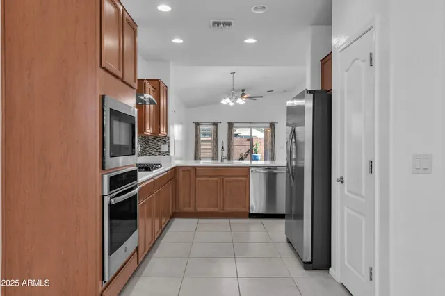 a view with kitchen island a sink a counter space and cabinets