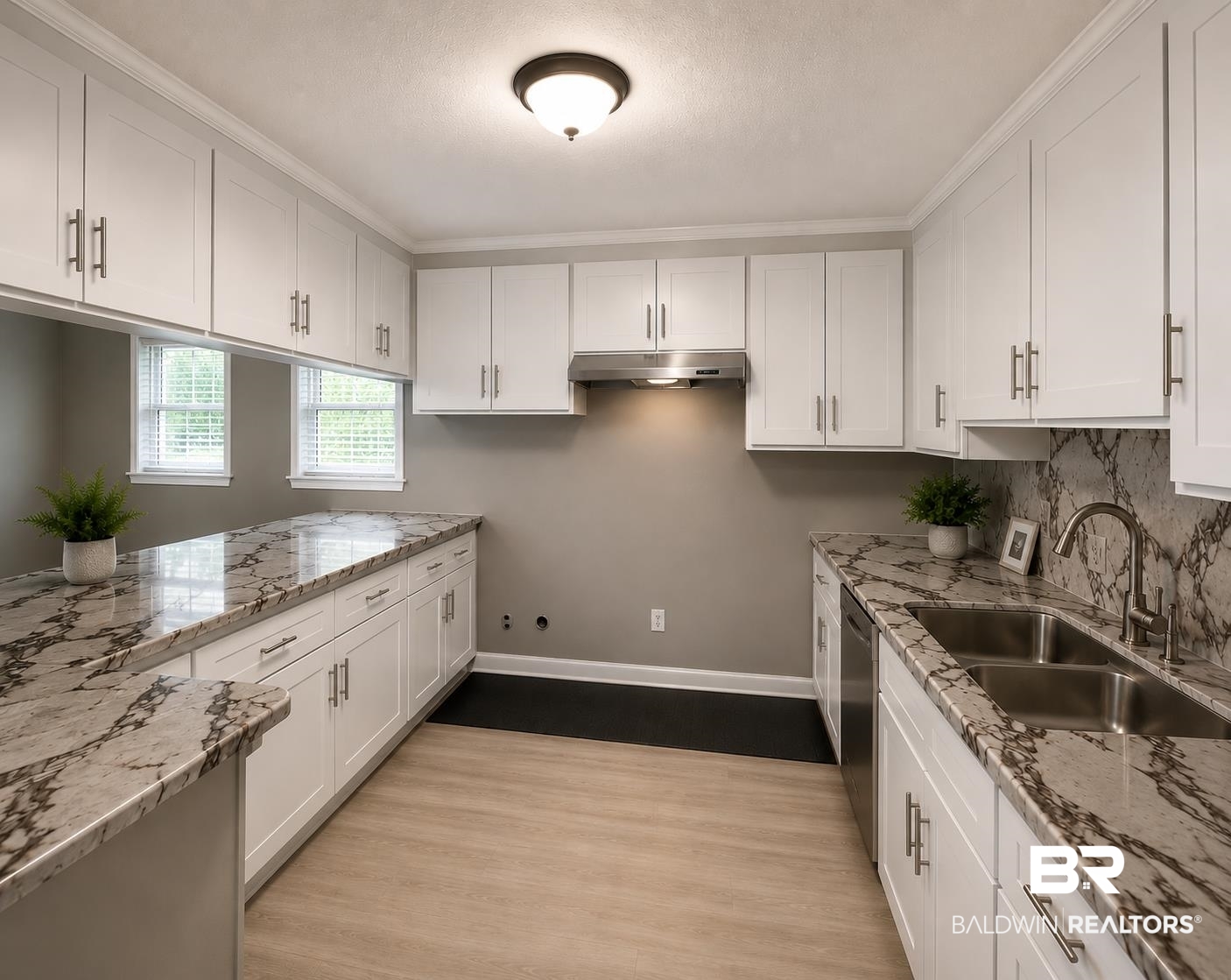 226 Elizabeth Street Evergreen, AL 36401 - Photo 11 of 35 Gourmet kitchen featuring extensive white cabinetry, light stone-finish countertops, stainless steel appliances, and wood-finish flooring