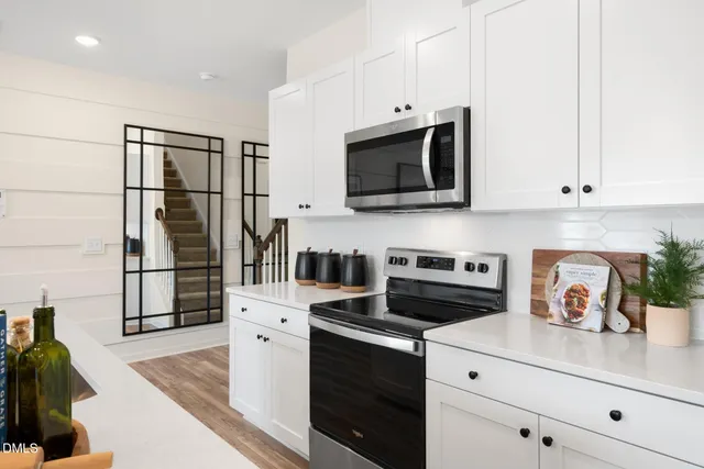 a kitchen with appliances a microwave and cabinets