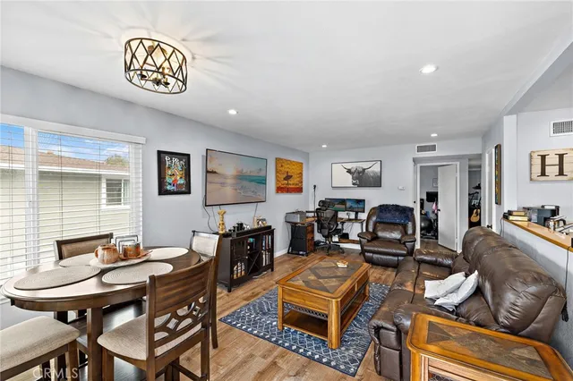 a living room with furniture kitchen view and a window