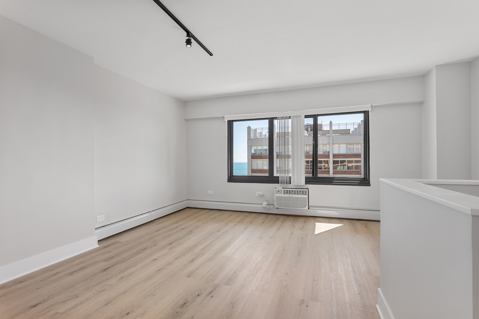 6166 North Sheridan Road, Unit 22F Chicago, IL 60660 - Photo 8 of 22 an empty room with wooden floor and windows