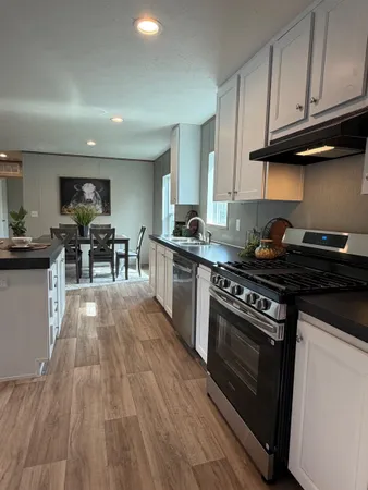 a kitchen with granite countertop wooden floors and stainless steel appliances