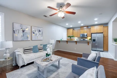 a living room with furniture a chandelier and a window