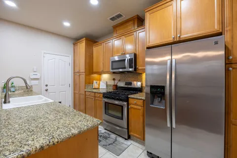 a kitchen with stainless steel appliances granite countertop a sink stove and refrigerator