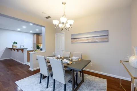 a view of a dining room with furniture wooden floor and chandelier