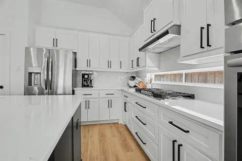 a kitchen with stainless steel appliances a stove a sink and cabinets
